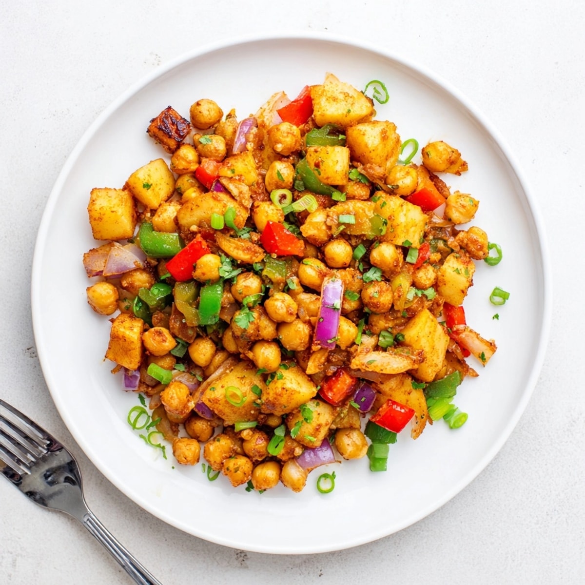 Golden-brown Cajun Chickpea Breakfast Hash recipe, ready to serve with fresh green onion.