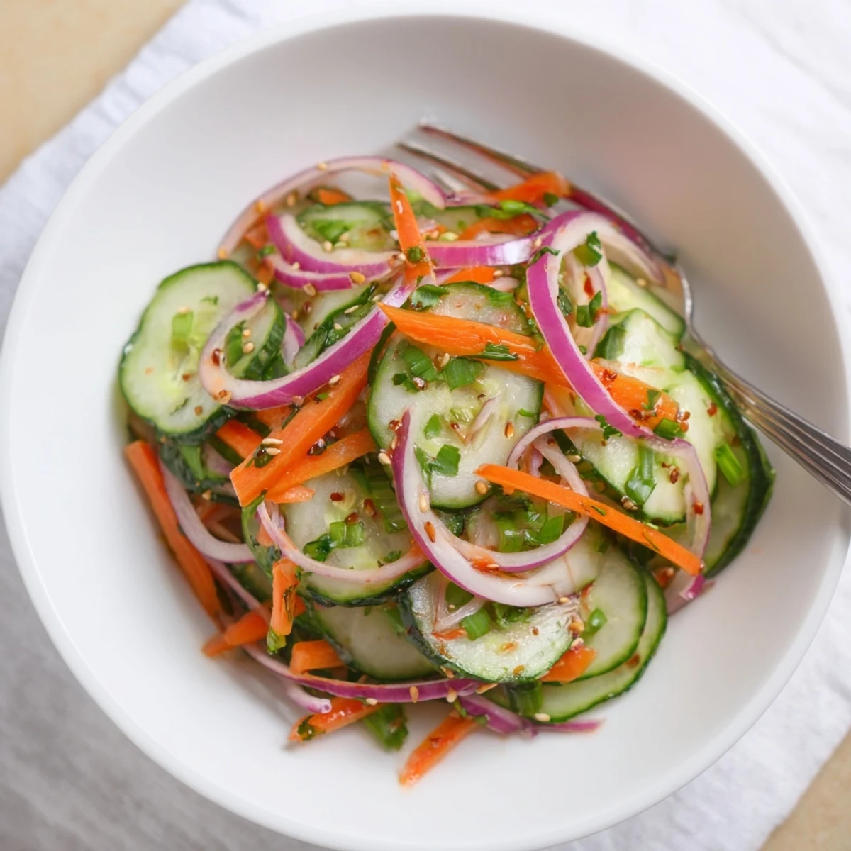 Refreshing Cucumber Salad Remix perfect for summer, tossed with tangy dressing and garnished.