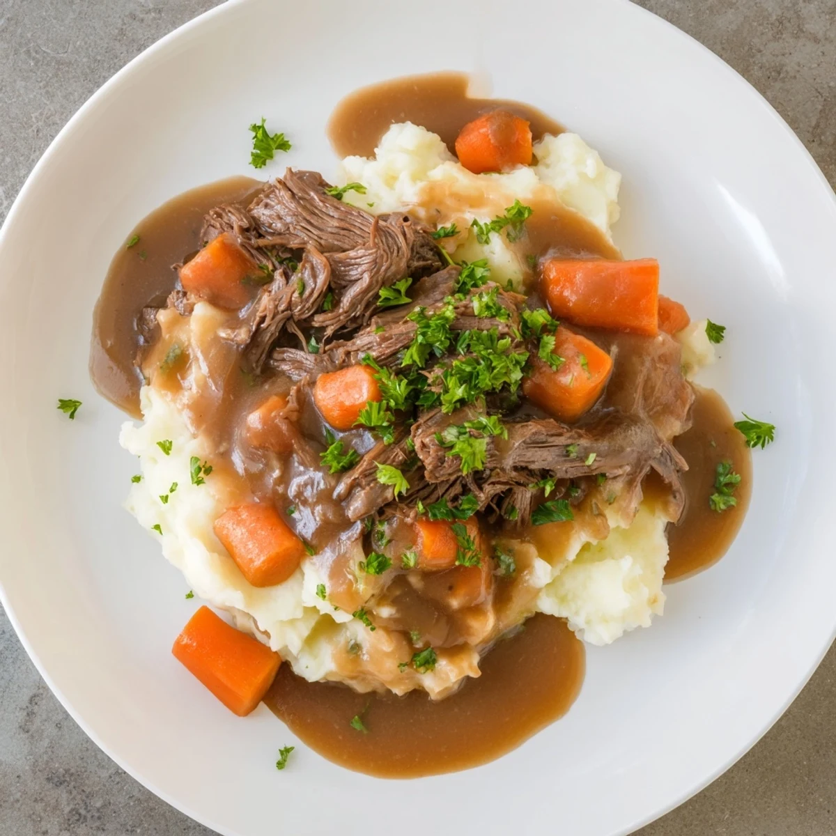Hearty slow cooker pot roast, steaming on a plate, alongside a generous portion of mashed potatoes.