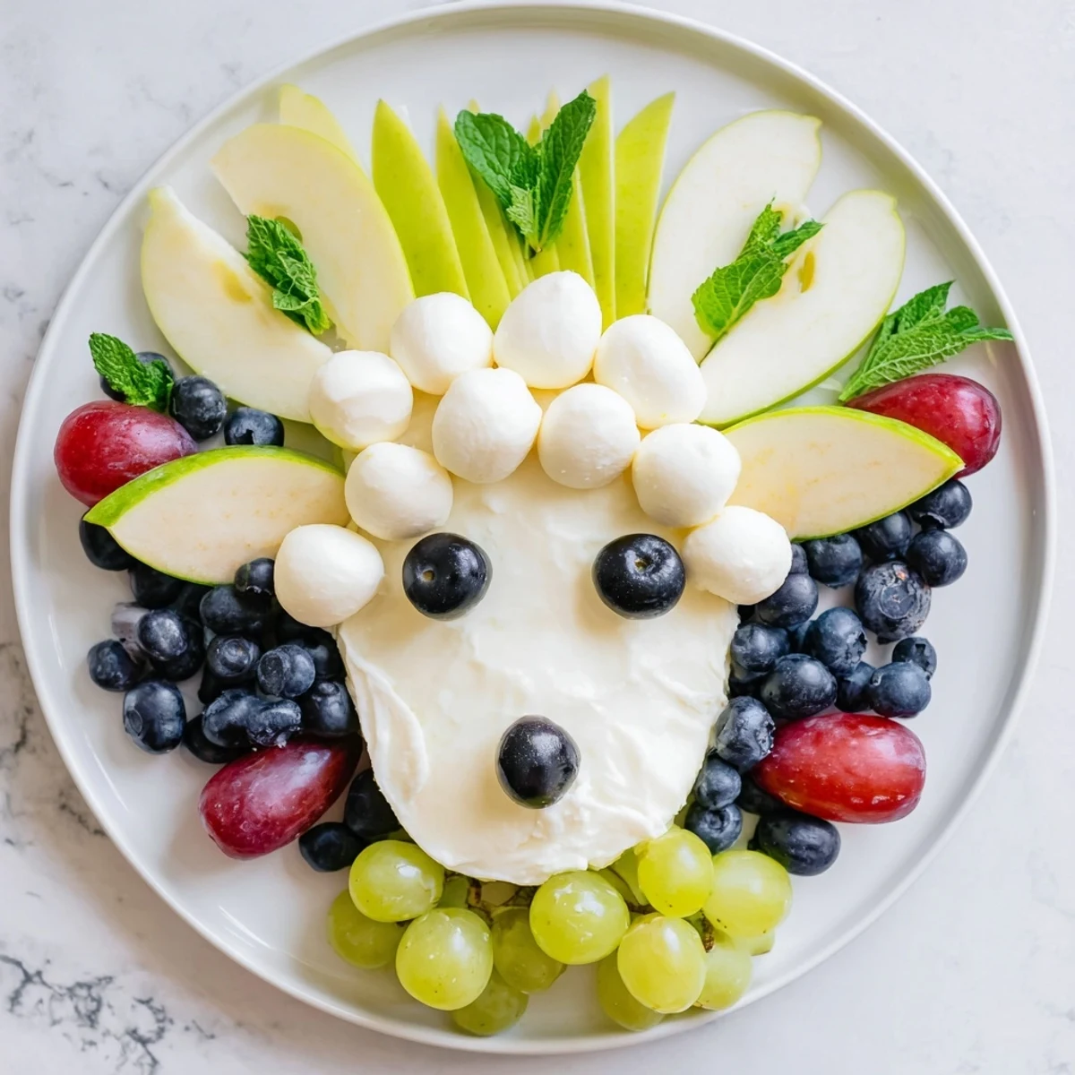 This Lamb Face Fruit and Cheese Platter offers a whimsical appetizer with colorful grapes and apples.