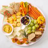 Delectable cheeses, fruits, and crackers arranged on a Pumpkin Patch Snack Board, perfect for fall gatherings.