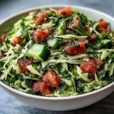 Shredded green cabbage, diced tomatoes, and crisp cucumbers tossed with fresh parsley and mint in a zesty lemon dressing in this vibrant Lebanese Cabbage Salad.
