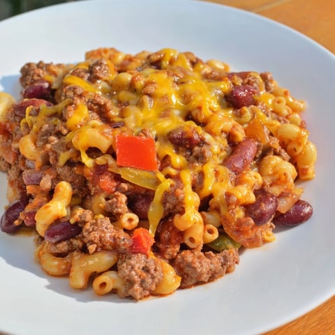 A cheesy, bubbling Cheeseburger Chili Mac Skillet, ready to scoop and enjoy on a plate.