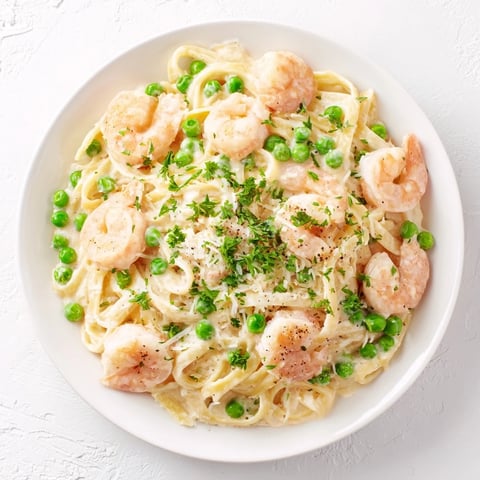 Vibrant photo of creamy Instant Pot Shrimp Alfredo Pasta, ready to serve with fresh parsley.