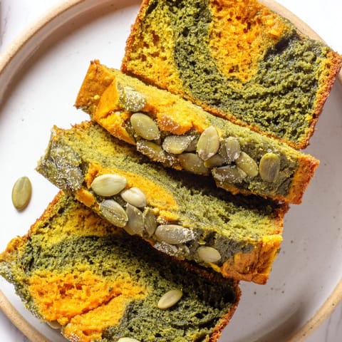 Sliced matcha pumpkin spice muffin loaf garnished with pumpkin seeds and warm spices.  