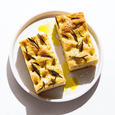 Homemade Holiday Bread focaccia, baked until golden, is topped with fresh rosemary sprigs.