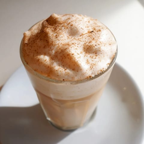 Homemade Dalgona coffee, a visually appealing drink with peaks of whipped coffee on cold milk, ready to enjoy.