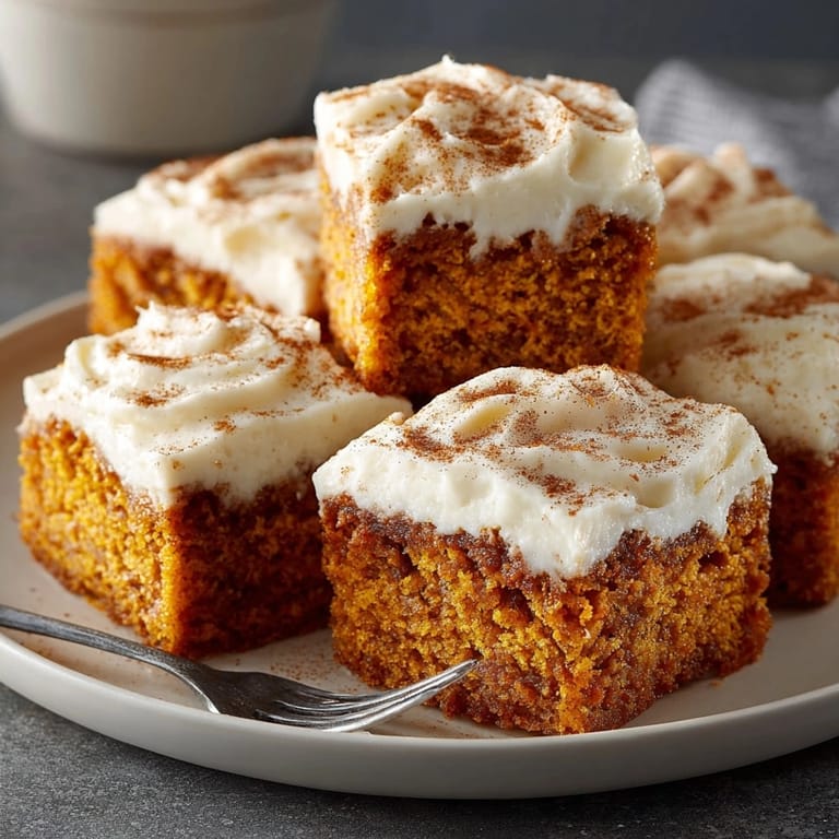 Warm, moist Pumpkin Spice Sheet Cake Squares, frosted and ready to serve.