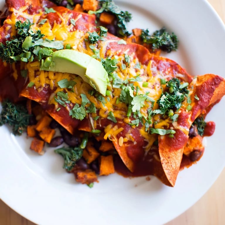 These comforting One-Pan Sweet Potato, Black Bean & Kale Enchiladas offer a delicious, cheesy, vegetarian main course.