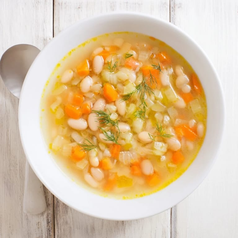 A bowl of Simple White Bean and Fennel Soup, steaming and ready to enjoy with crusty bread.