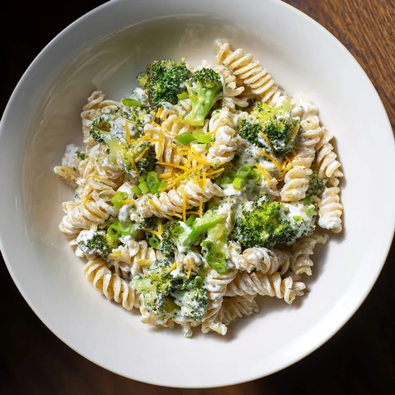 A bowl of Green Goddess Broccoli Cheddar One-Pot Pasta, garnished with fresh herbs, ready to serve perfectly.