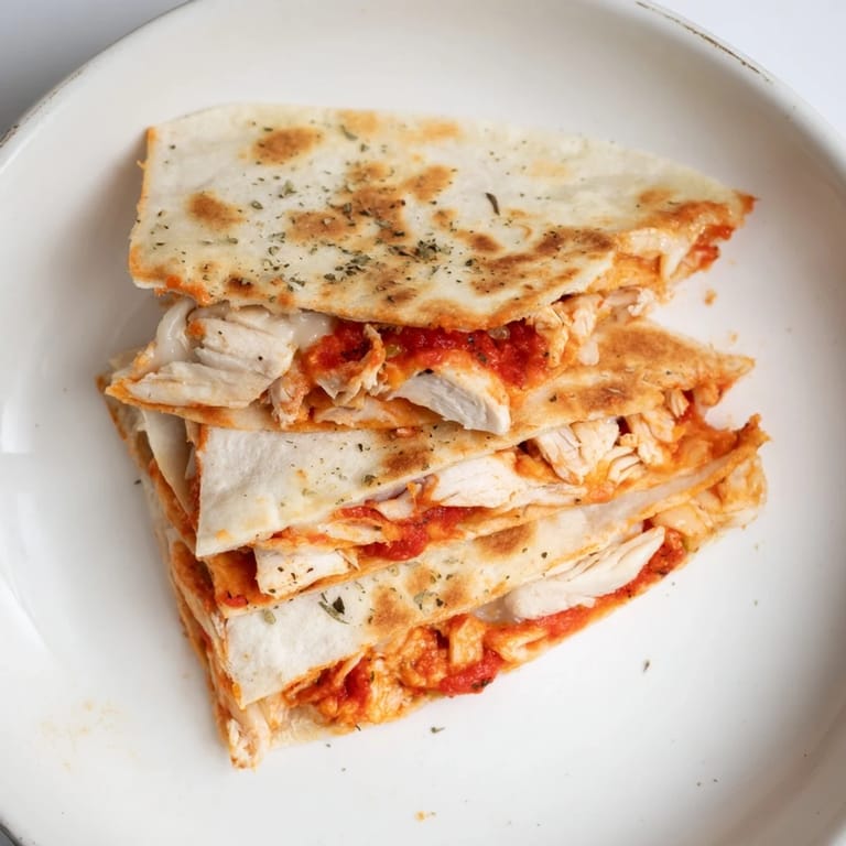 Golden brown tortilla pizza wrap with chicken, a quick and delicious Italian-American meal.