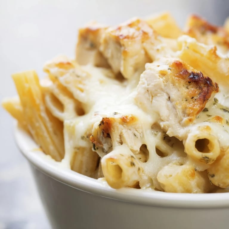 A close-up of Chicken Ranch Pasta Bake showing tender chicken, penne pasta, and a rich ranch sauce.