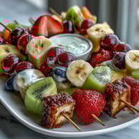 Fun Kid Lunch Bento Box with Fruit Skewers and Dip features colorful fruit kebabs, creamy yogurt dip, and wholesome sandwich bites.  