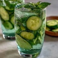 Sparkling Cucumber Mint Lemonade Mocktail glistening with ice and fresh garnishes.